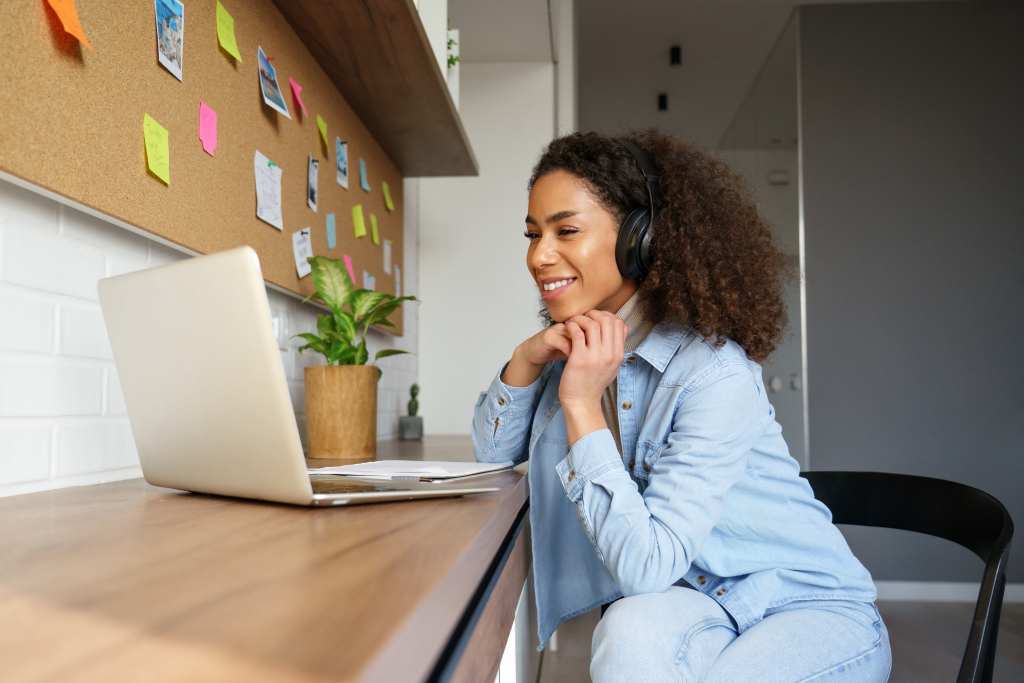 happy woman smiling at laptop online learning